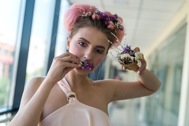 Mode portrait de jeune femme avec des fleurs dans la bouche