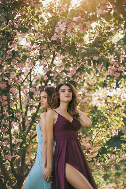 Mode portrait photo de deux femmes près de l'arbre en fleurs sur la nature