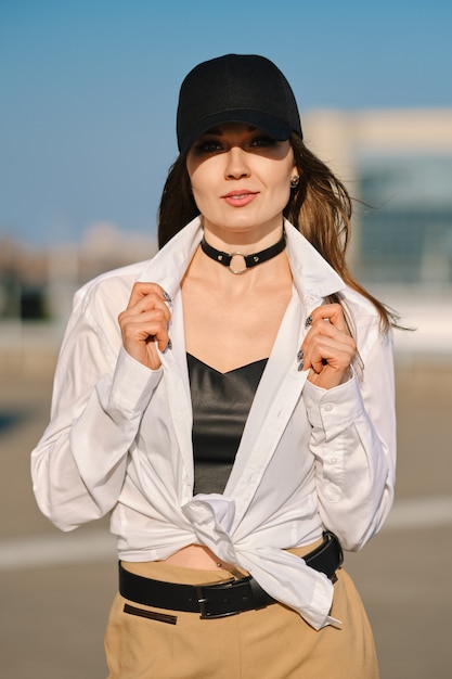 Mode de rue, tenue décontractée et tendance pour femmes. Femme en tailleur-pantalon, débardeur en cuir et bottes rugueuses en plein air.