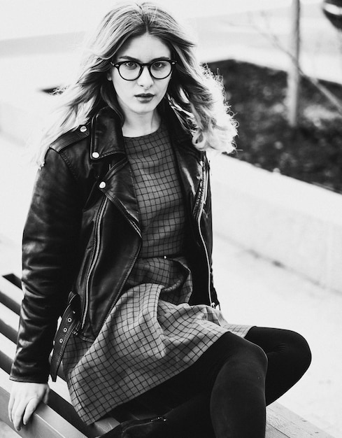 Mode de vie et concept de personnes fille blonde assise sur un banc photo noir et blanc de la ville d'été