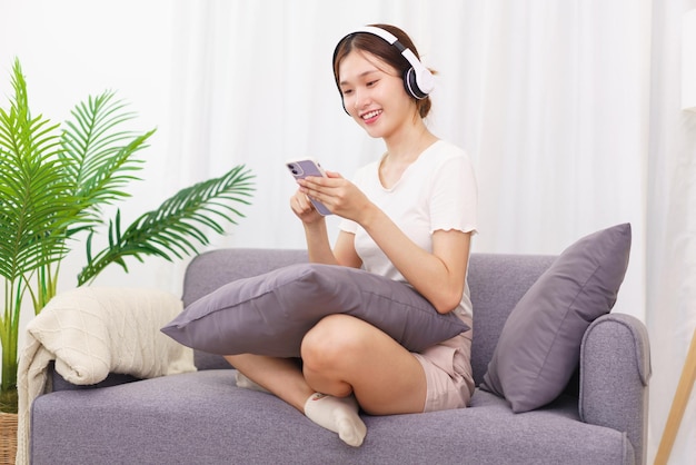 Mode De Vie Dans Le Concept De Salon Jeune Femme Asiatique Au Casque Pour écouter De La Musique Sur Smartphone