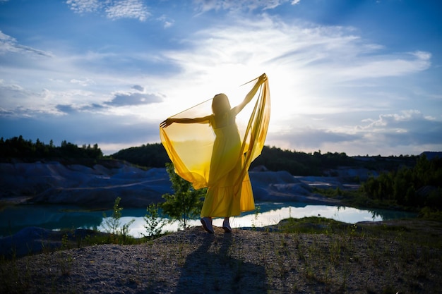 Mode de vie estival d'une superbe femme heureuse qui court dans la nature. Dans une longue robe jaune. Humeur romantique. Profiter du soleil. Journée ensoleillée. Mise au point sélective