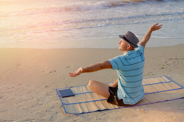 Mode de vie de l'été portrait joie masculine sur la plage au bord de la mer style de vie matin au lever du soleil