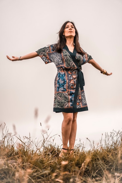 Mode de vie, fille brune profitant de la nature avec une robe colorée