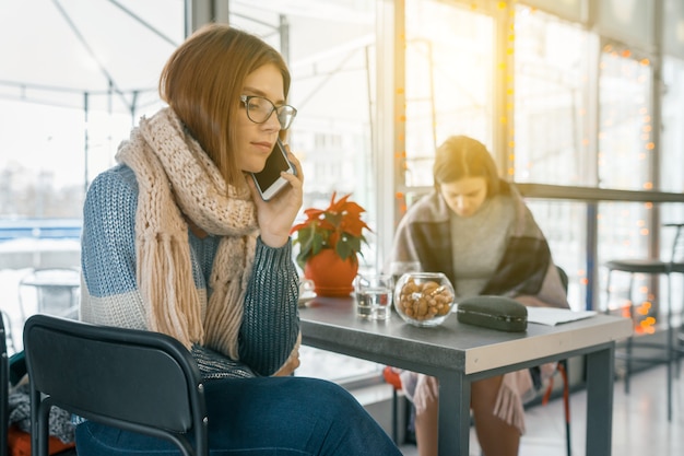 Mode de vie d'hiver, les gens au café avec des téléphones portables