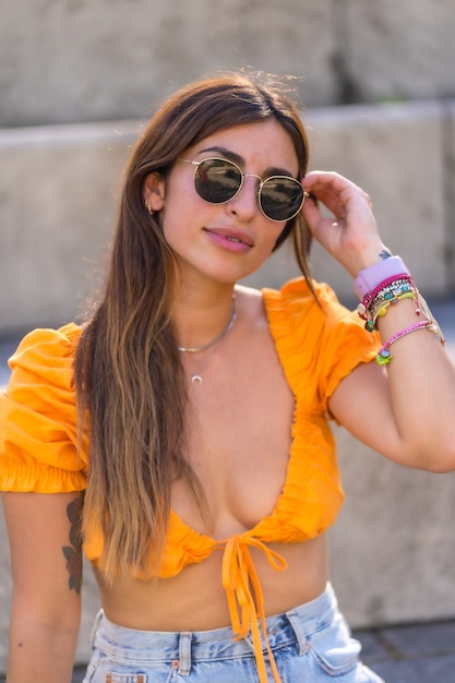 Mode de vie d'une jeune brune caucasienne marchant en été dans un parc de la ville. Portrait de la jeune fille regardant la caméra et souriant