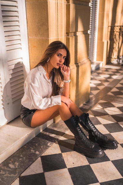 Mode De Vie D'une Jeune Brune Dans Une Jupe En Cuir Noir Et Une Chemise Blanche