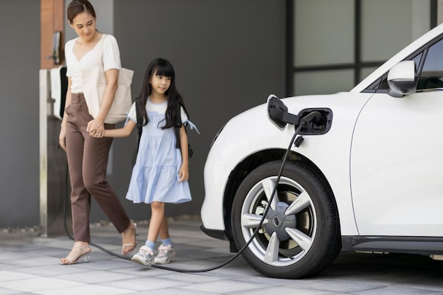 Mode de vie progressif de la mère et de la fille avec voiture EV et station de charge