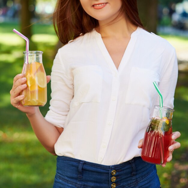 Mode de vie sain. Jeune femme méconnaissable avec smoothie de désintoxication aux fruits en été, sur fond de nature verdoyante