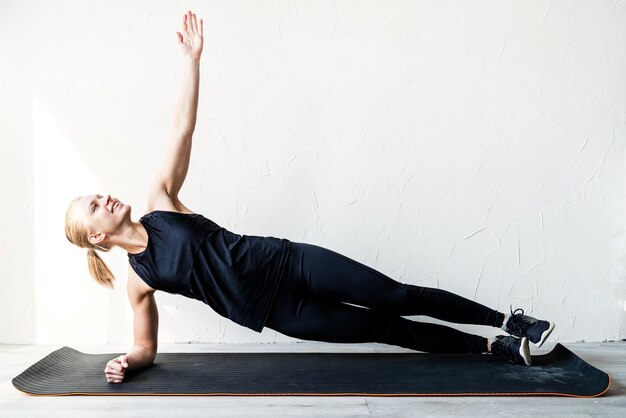 Mode de vie sain sport et fitness jeune femme blonde s'entraînant à la maison en position de planche