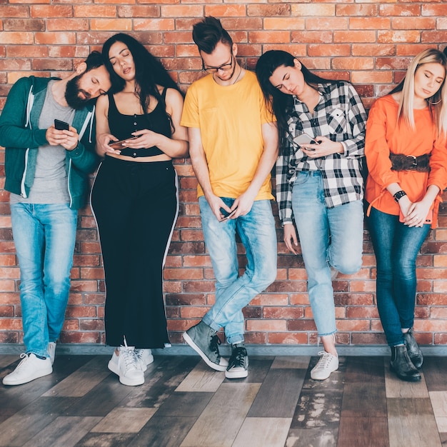 mode de vie technologique. dépendance aux réseaux sociaux. millénaires avec des smartphones en main.