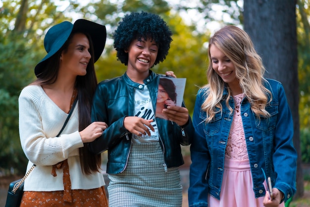 Photo mode de vie. trois bons amis dans un parc, une blonde, une brune et une fille latine aux cheveux afro