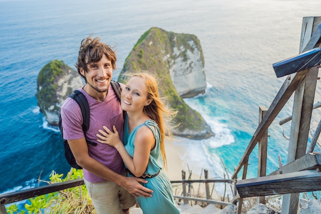 Mode de vie de vacances en famille Heureux couple homme et femme debout au point de vue Regardez la belle plage sous la haute falaise Destination de voyage à Bali Endroit populaire à visiter sur l'île de Nusa Penida