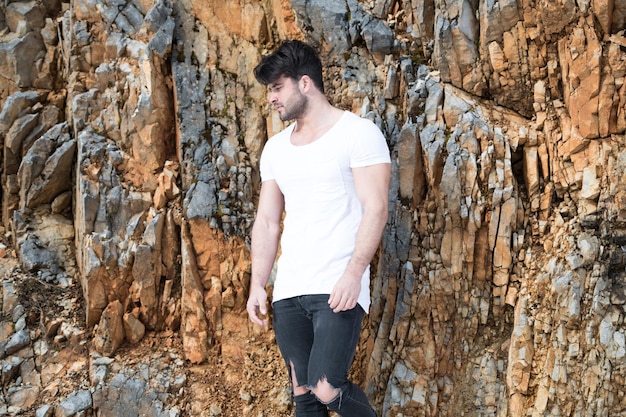 Photo model flexing muscles contre un mur de briques