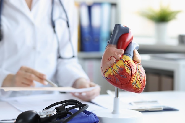 Photo modèle anatomique du coeur sur la table des médecins floue