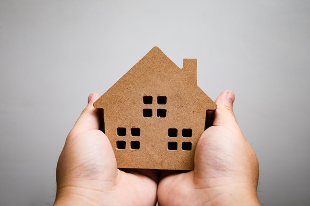 Le modèle d'architecture de la maison à la main, la construction de bâtiments, l'immobilier et le concept de propriété