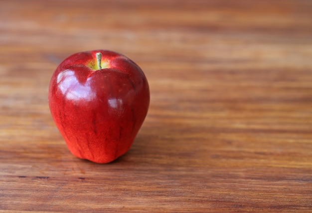 Modèle artificiel de fruits pomme rouge sur une table en bois.