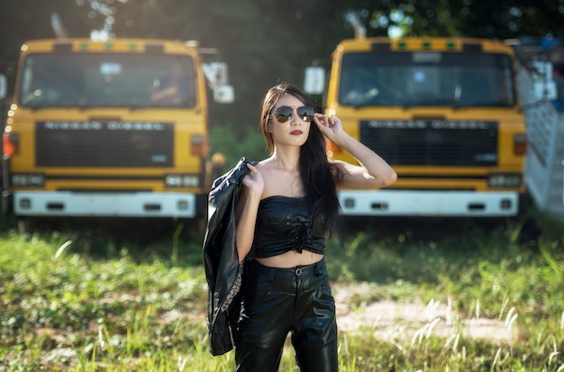 Modèle asiatique pose avec camion dans un environnement extérieur