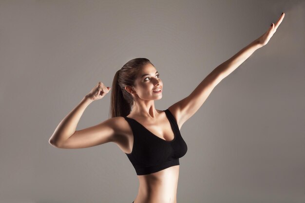 Modèle attrayant avec une bonne silhouette faisant de la musculation en studio