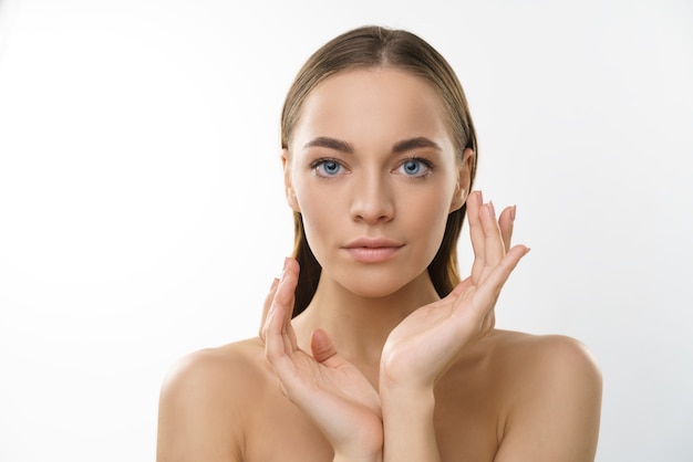 Modèle de beauté jeune femme blonde aux yeux bleus avec maquillage naturel et peau saine sur fond blanc