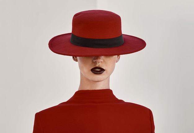 Modèle de beauté et de style dans un studio avec un visage glamour et une routine de maquillage Personne élégante et féminine avec un chapeau de fantaisie pour accessoire avec une mode élégante isolée par un fond blanc