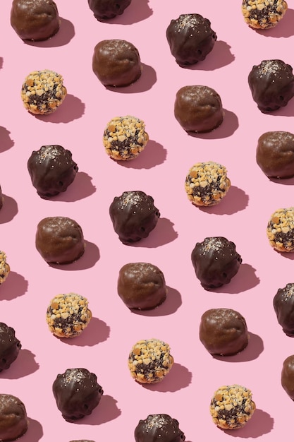 Modèle de bonbons aux noix artisanales au chocolat sur fond rose Fond d'aliments sucrés