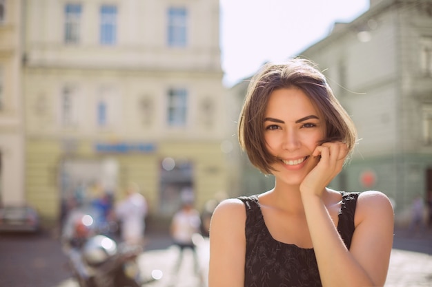 Modèle brune positive avec bronzage bronze et maquillage naturel marchant dans la rue. Espace pour le texte