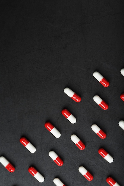 Un modèle de capsules de pilules rouges et blanches sur fond noir