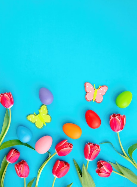 Modèle de carte de Joyeuses Pâques à plat décoration d'oeufs de Pâques et de tulipes sur fond bleu