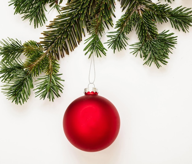 Modèle de carte de voeux Noël Nouvel An Boule rouge et brindille de sapin frais sur fond de couleur blanche