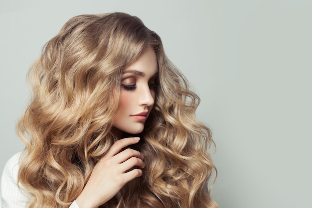 Modèle de cheveux femme avec une longue coiffure blonde sur fond blanc