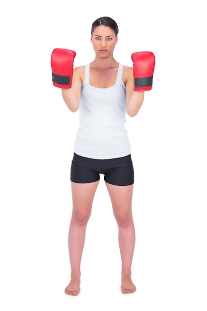 Modèle en colère en bonne santé avec des gants de boxe posant