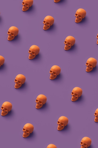 Modèle de crânes orange sur fond violet Idée Halloween concept minimal