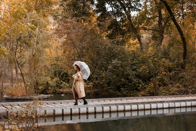 Modèle dans un parc de la ville lors d'une promenade à l'automne sous la pluie. automne