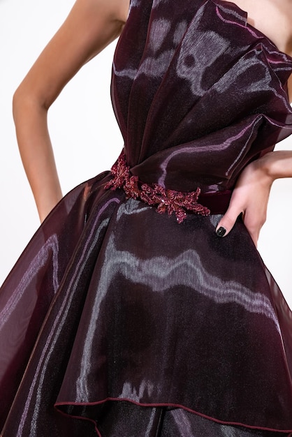 Un modèle dans une robe violette avec une fleur rouge sur le bas