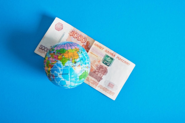 Modèle du globe et un billet de 5000 roubles fond bleu