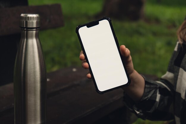 Modèle d'écran blanc de médias sociaux de téléphone portable pour l'application mobile Bouteille d'eau thermo en acier réutilisable