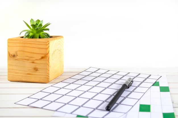 Photo modèle d'espace de travail de bureau à domicile avec plante de stylo de portable dans un pot en bois et accessoires sur blanc