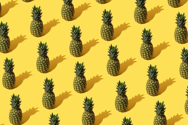 Photo modèle d'été avec des ananas sur fond jaune