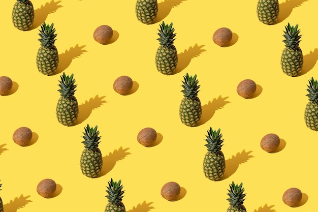 Photo modèle d'été avec ananas et noix de coco sur fond jaune