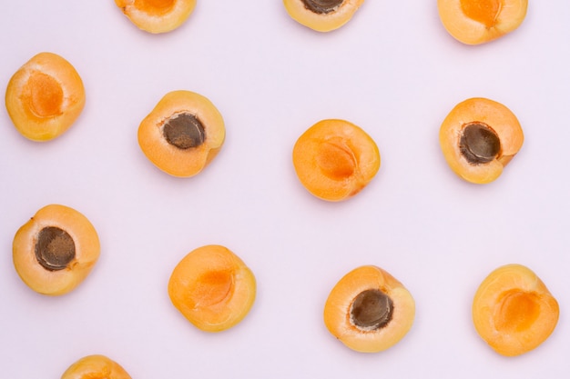 Modèle d'été de fruits colorés d'abricots frais sur fond rose. Vue de dessus, pose à plat.