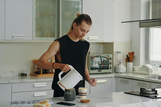 Modèle faisant du café dans la cuisine