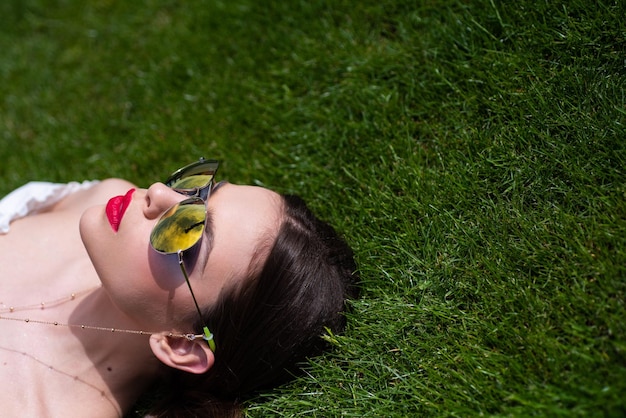 Modèle féminin chic élégant dans des lunettes de soleil de mode belle jeune brune avec une peau parfaite et longue