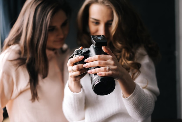 Modèle féminin et femme photographe regardant des photos en studio Concept de travail créatif dans les coulisses du studio photo