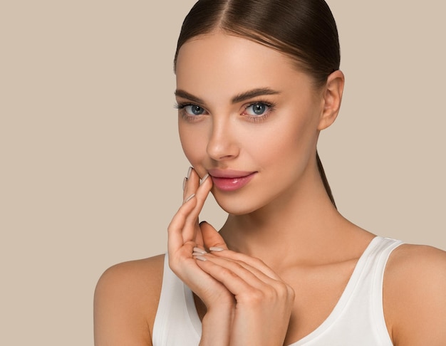 Modèle de femme belle peau avec les mains. Beauté maquillage naturel visage lèvres roses. Fond de couleur marron