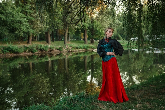 Modèle fille aux cheveux blancs dans une robe rétro à volants dans un parc verdoyant