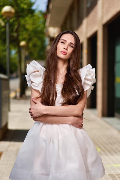 Modèle de fille dans une robe blanche dans la rue