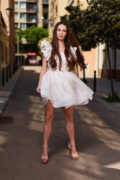 Modèle de fille dans une robe blanche dans la rue