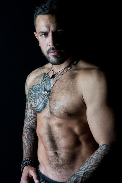 Modèle en forme avec tatouage sur la peau Homme barbu avec poitrine tatouée Macho avec torse nu sexy Sportif ou athlète avec barbe et cheveux élégants Sport ou fitness et soins du corps Force et motivation