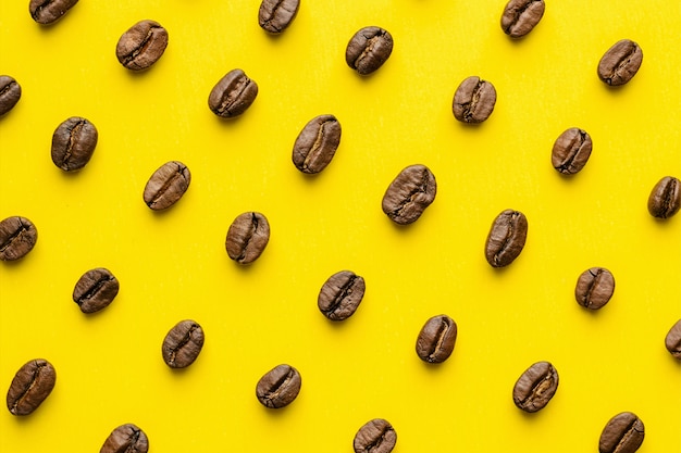 Modèle de grains de café sur fond jaune